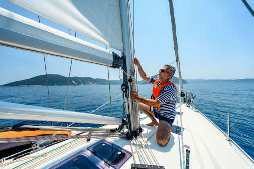 Man inspecting the anatomy of a boat changing the sails